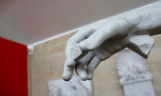 Statue of a hand holding a six-sided die
