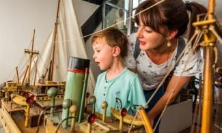 A child and grown-up looking at museum objects