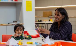 An adult and child at a table with craft materials
