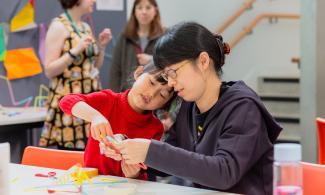 An adult and child at a table with craft materials