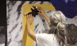 A person in front of an artwork