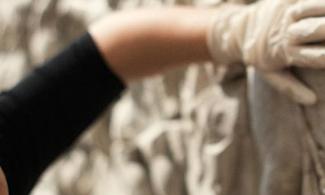 Woman wearing gloves touches a plaster relief