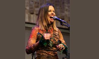 Singer Caru Lins in front of a microphone
