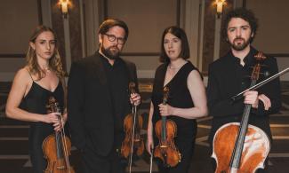 4 musicians holding cellos and violins on a dark background