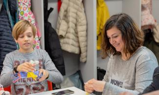 A child and a woman smiling during a creative workshop at Kettle's Yard.