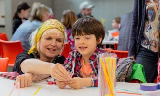 A child and a woman smiling during a creative workshop at Kettle's Yard.