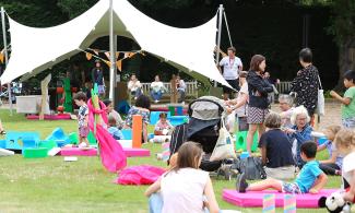 Individuals seated on the grass, engaged in conversation and relaxation