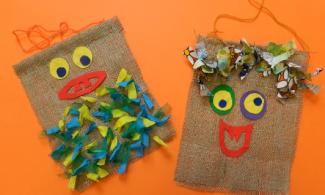 Two hessian bags on an orange table decorated with smiley faces.