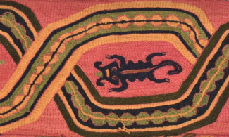 Part of an embroidered band featuring a design that includes lizard-like creatures. The band is reddish-pink in colour and the pattern uses black, green and cream thread.