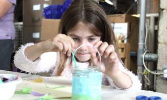 Girl decorating a glass lantern