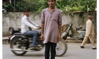 Man stood in a busy street with a blurred background