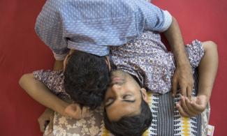 Two men sleeping together on a patterned rug