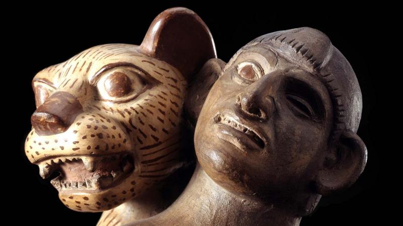 Pottery bottle in form of nude man with jaguar (covered in cream slip and markings in dark red) seizing the man from behind from Peru
