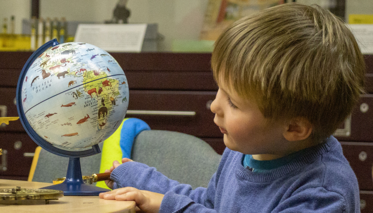 Little boy looking at globe