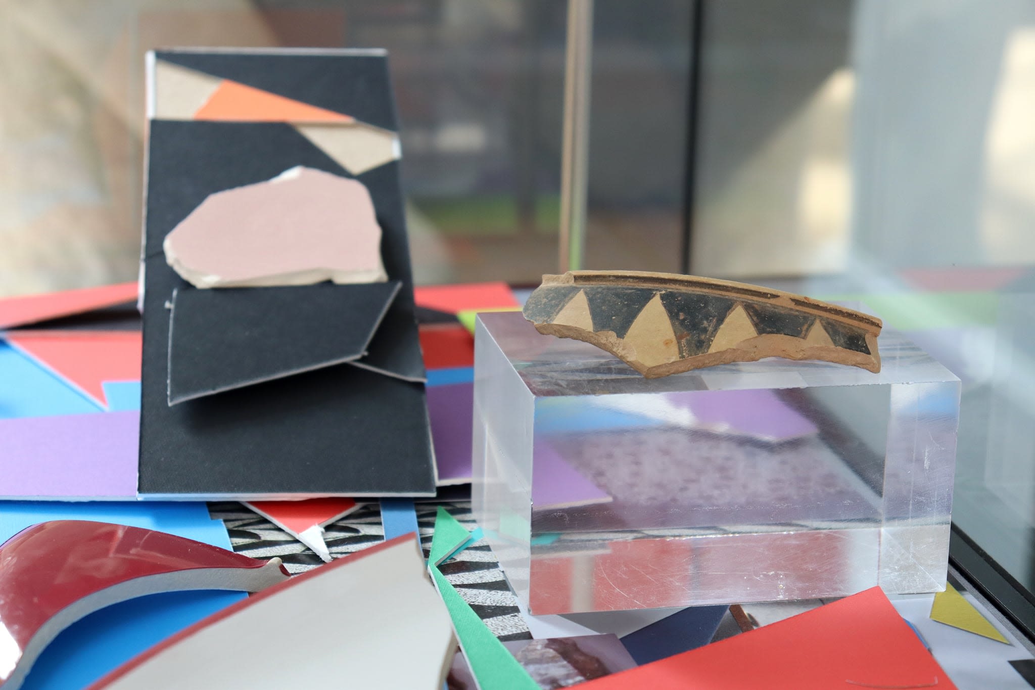 Close up of works in display case, an ancient ceramic rim sits on a mount