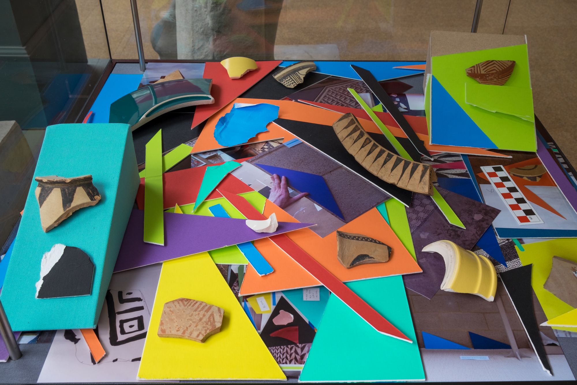 Arrangement of Coloured mountboard, photographs, broken ceramics and ancient sherds.