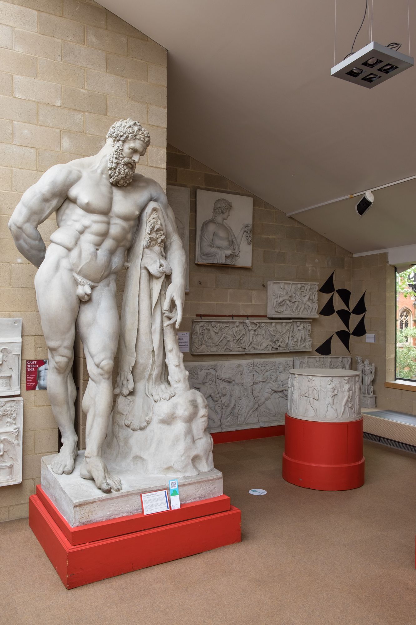 Black geometric shapes in the corner of the museum, the Farnese Hercules from the baths of Caracalla is in the foreground.