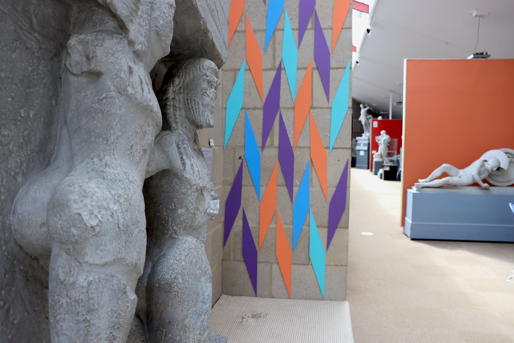 Thin wall with coloured diamond shaped mountboard arranged in a pattern.