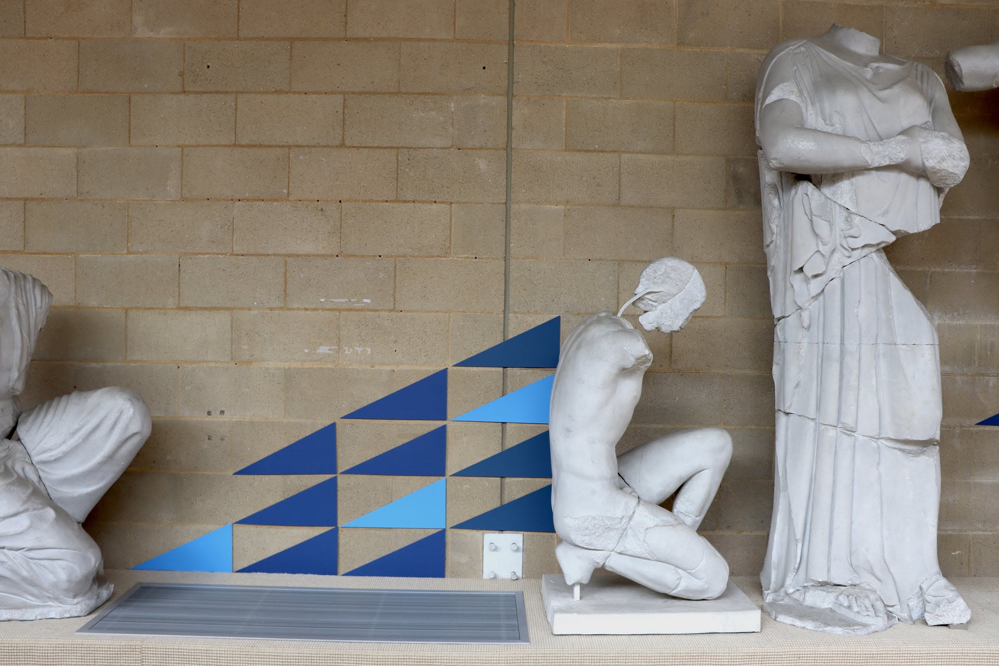 Coloured mountboard triangles that look like the emerge from a statues back.