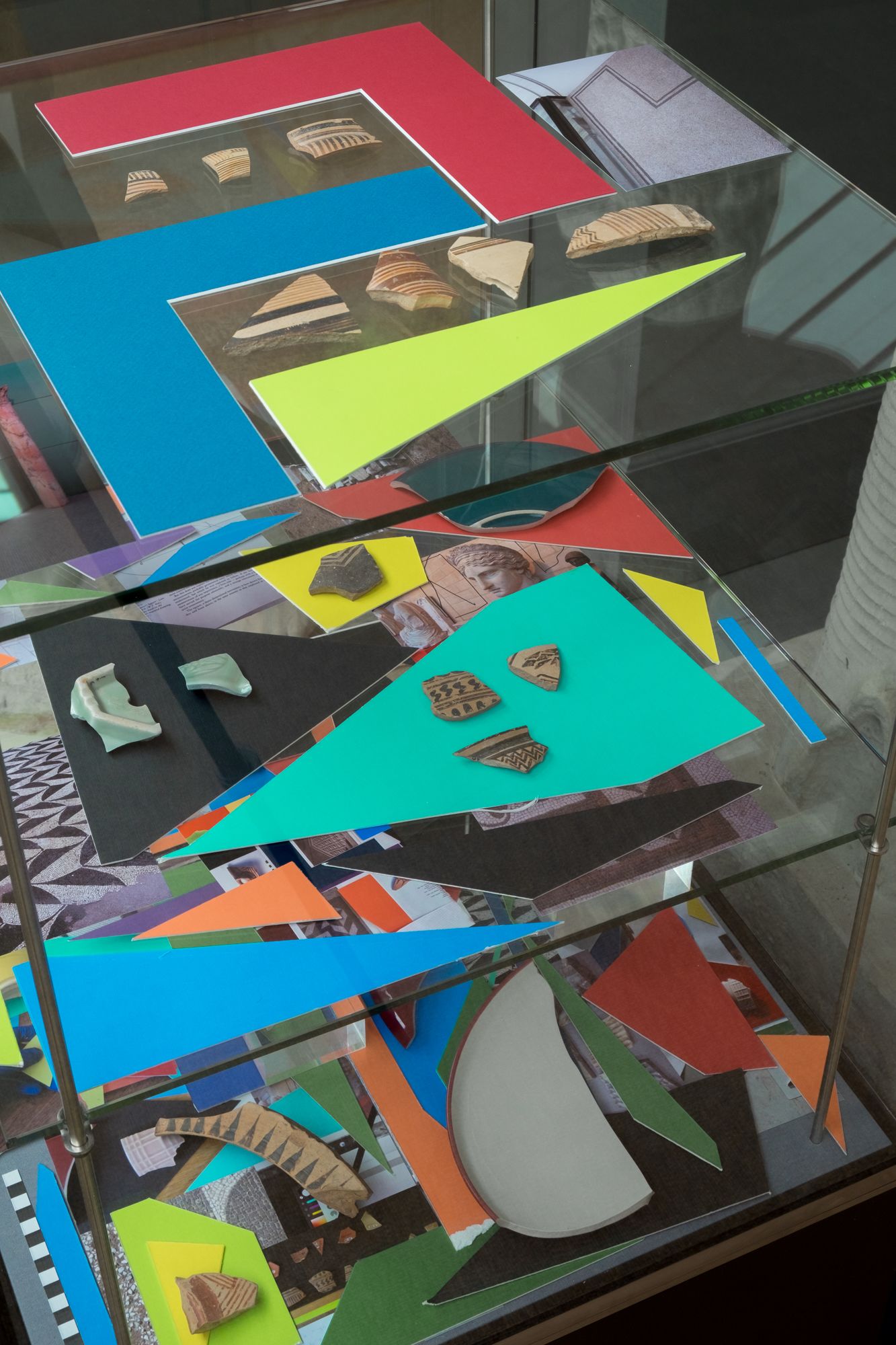 Arrangement of Coloured mountboard, photographs and broken ceramics.