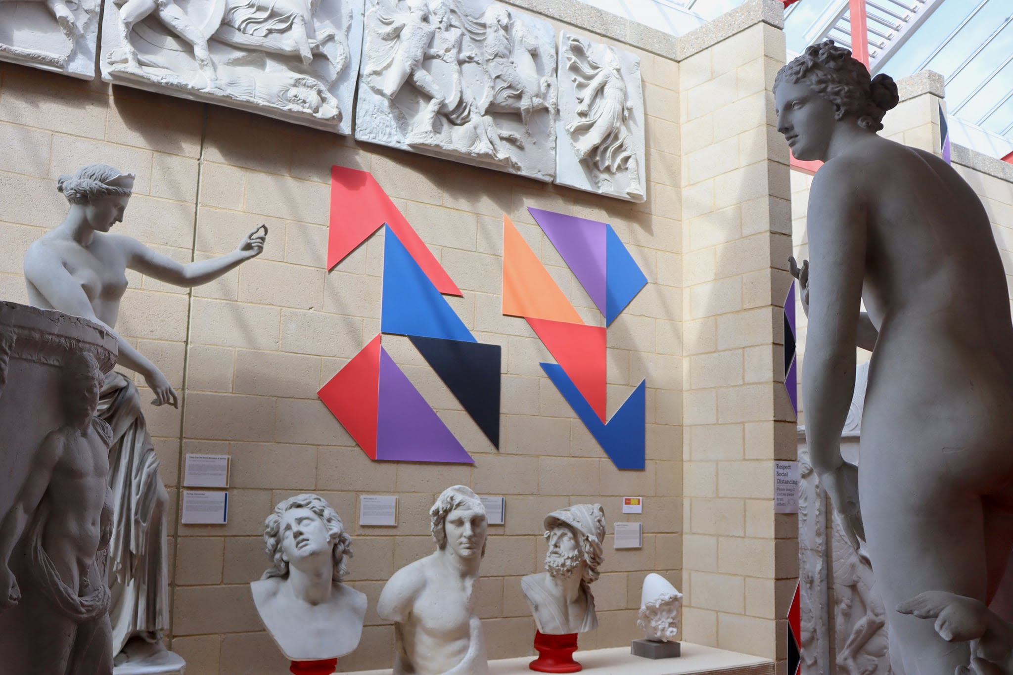 Large shapes mounted on the wall, surrounded by plaster casts