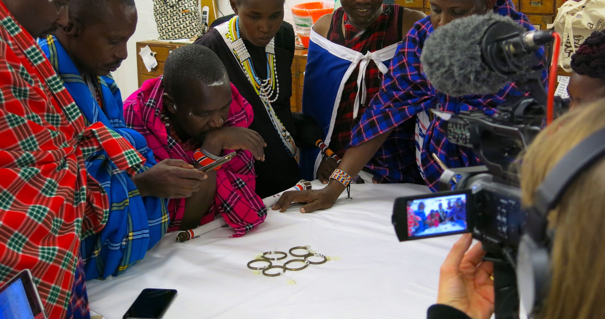 Maasai activists and cultural spiritual leaders looking at an object on a table