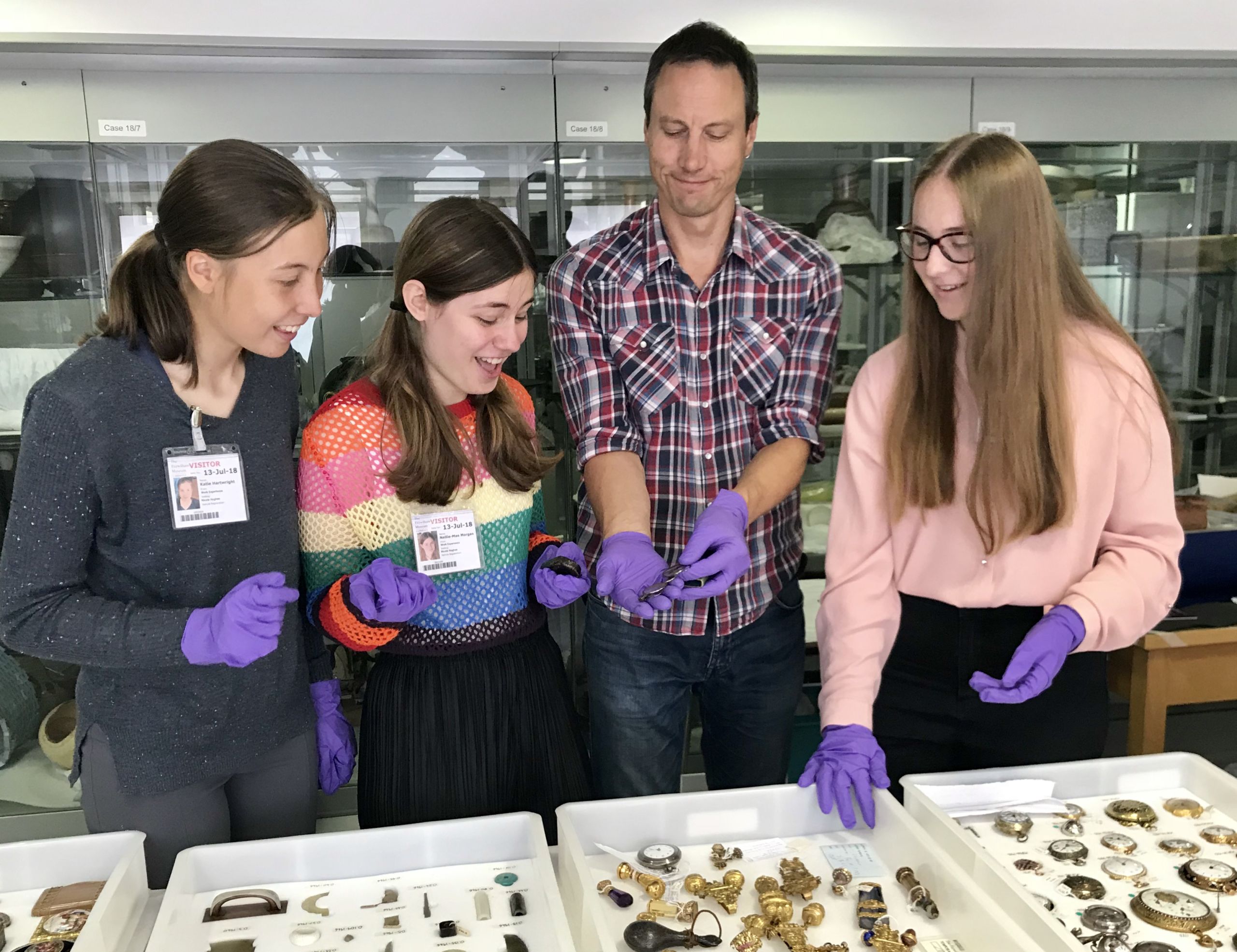 Four people looking at an object in the Fitzwilliam Museum