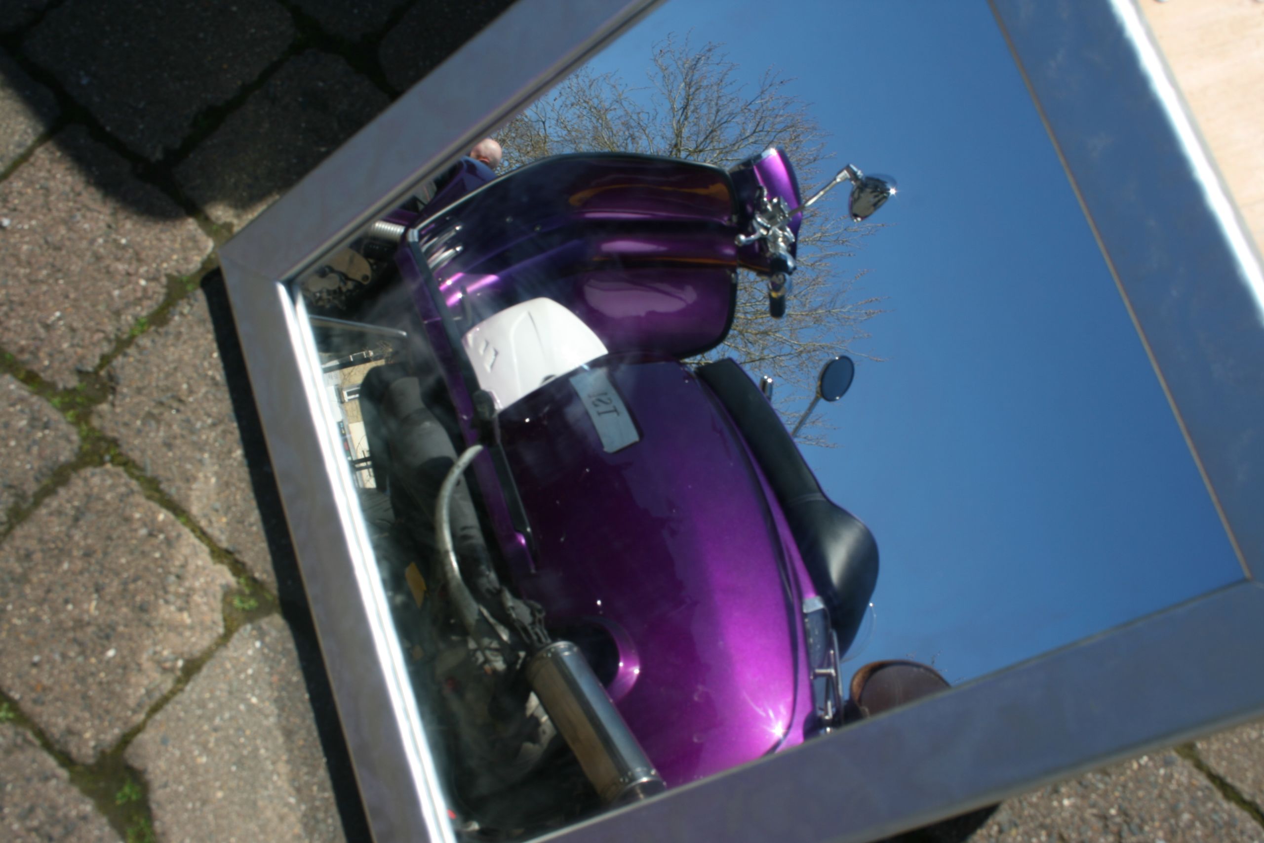 bright purple vespa reflected in a mirror