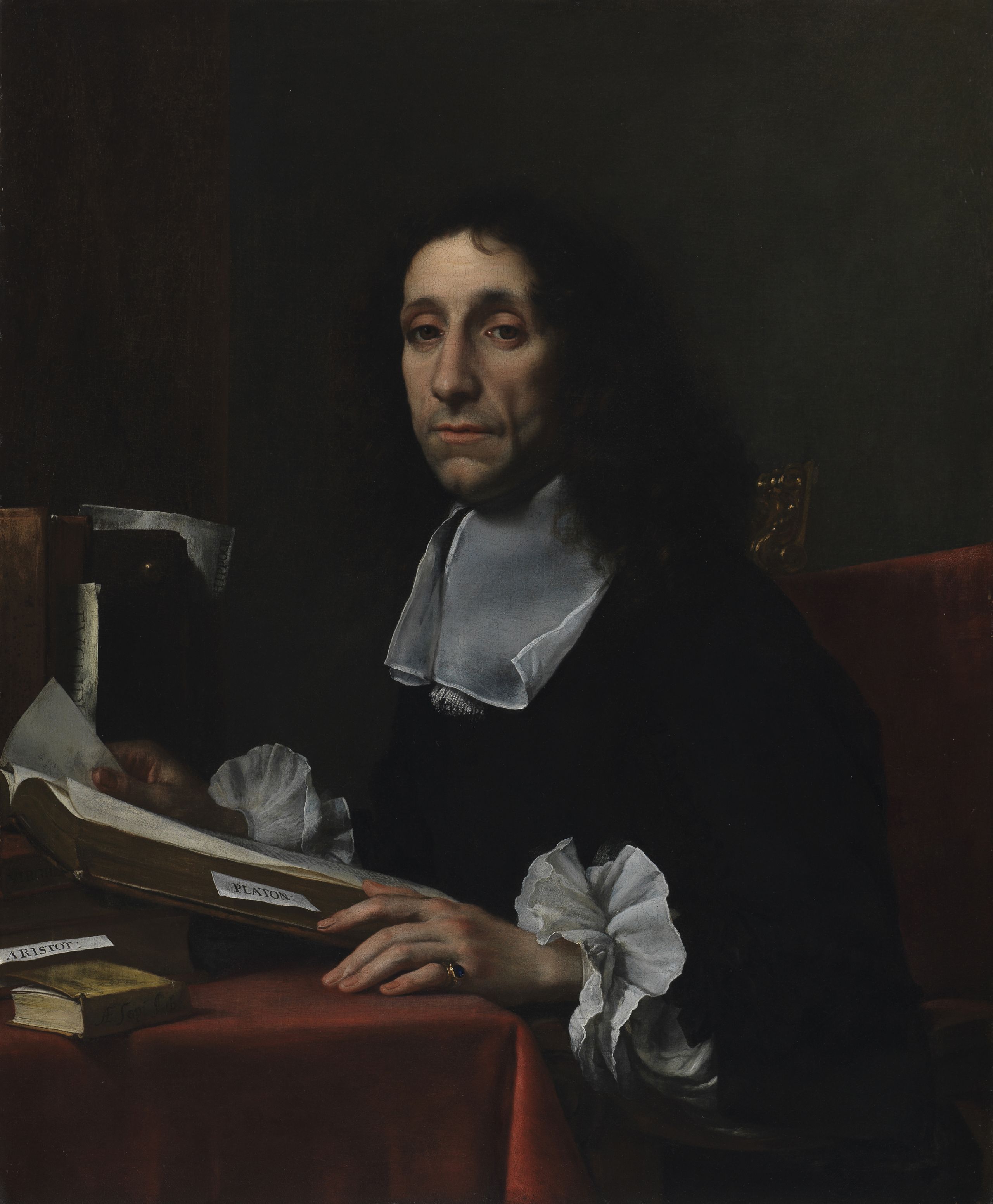 In this oil painting, Sir Thomas Baines is posed facing left, but turned towards the viewer. He is sitting at a desk, covered with a red tablecloth. His square, plain, but very delicate white collar and frilled cuffs draw the attention. Books rest on the desk, with a volume of Plato visible. A large volume is open in front of him, with a tab for notes. His left hand, which rests on the table by the open book, has fine long fingers and wears a ring. He has shoulder-length curly dark hair, heavy-lidded eyes, and is half-smiling.